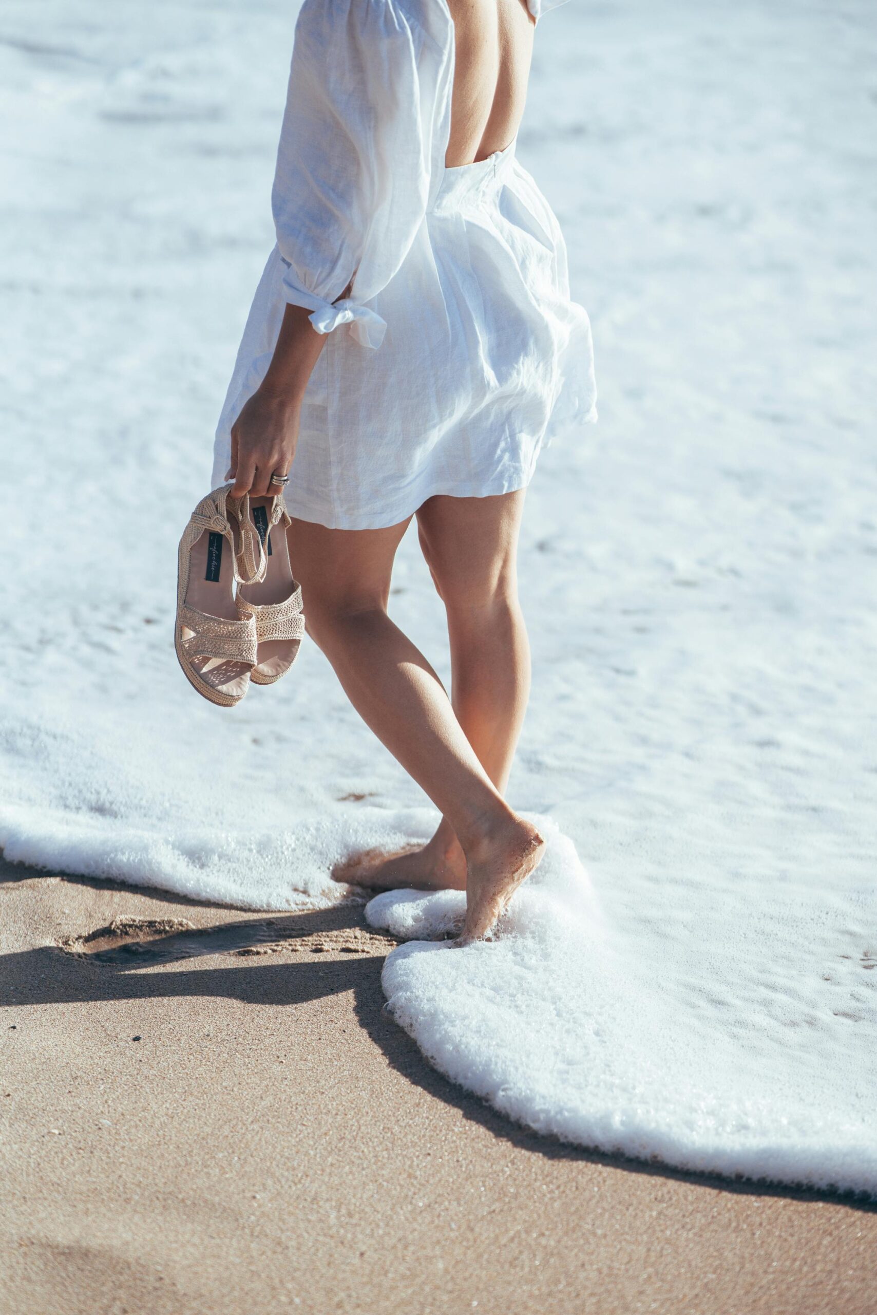 woman carrying sandals